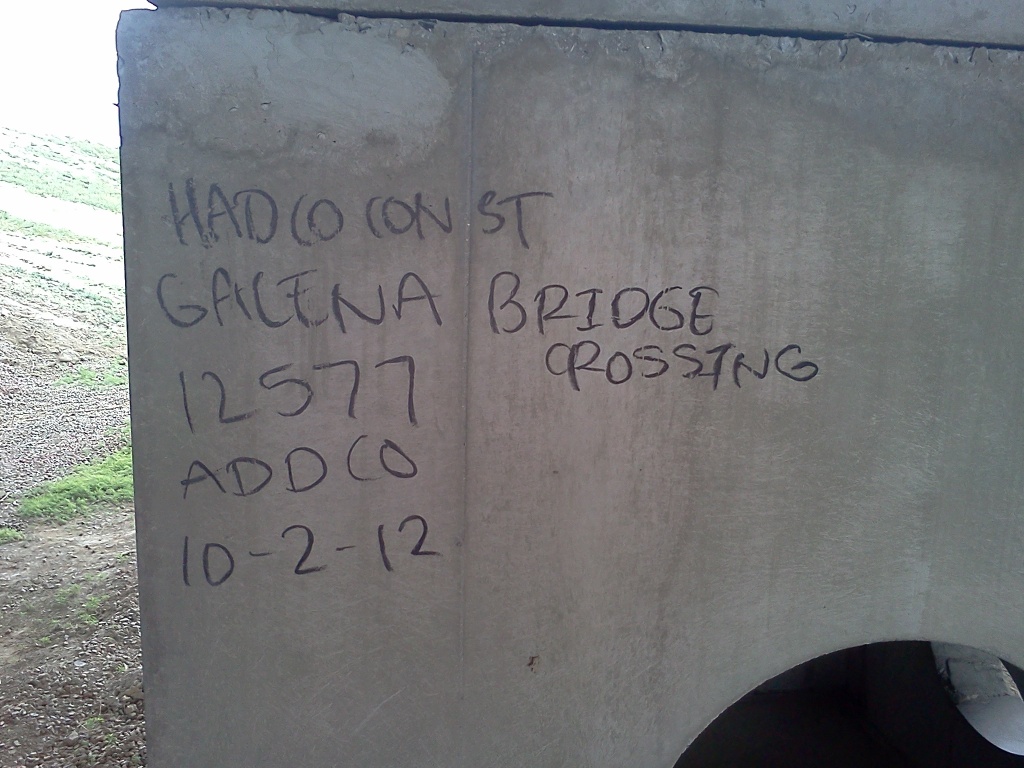 Some worker's construction notes scrawled in Sharpie on a jersey barrier.